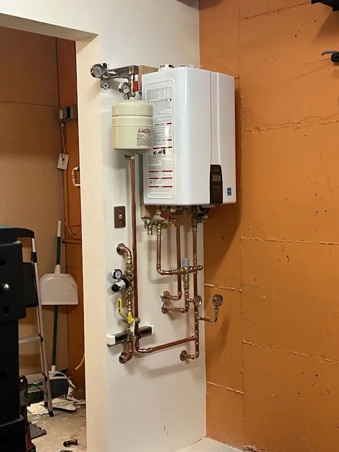 Plumbing technician inspecting water heater connections in West Liberty